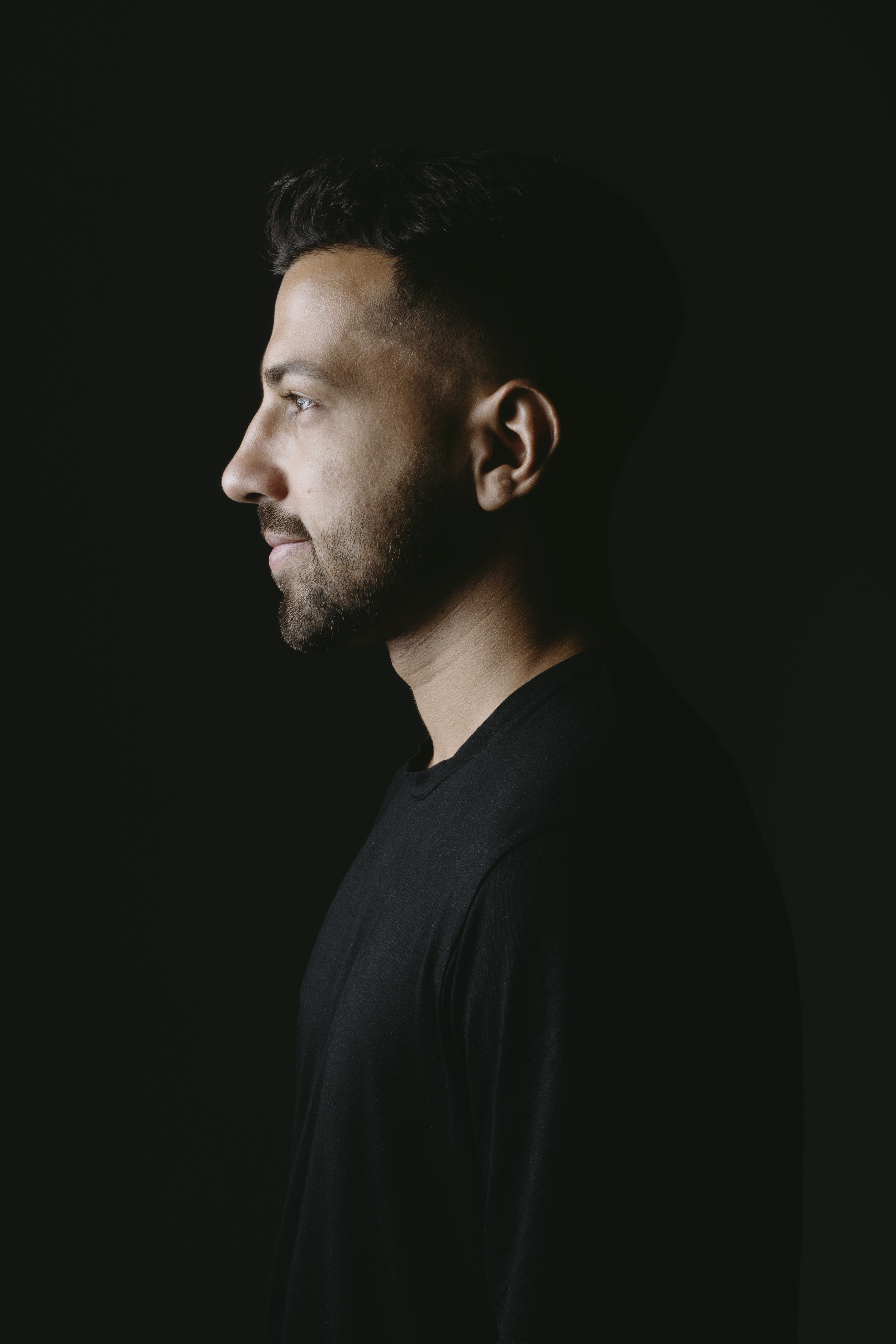 Side-profile portrait against a near-black background