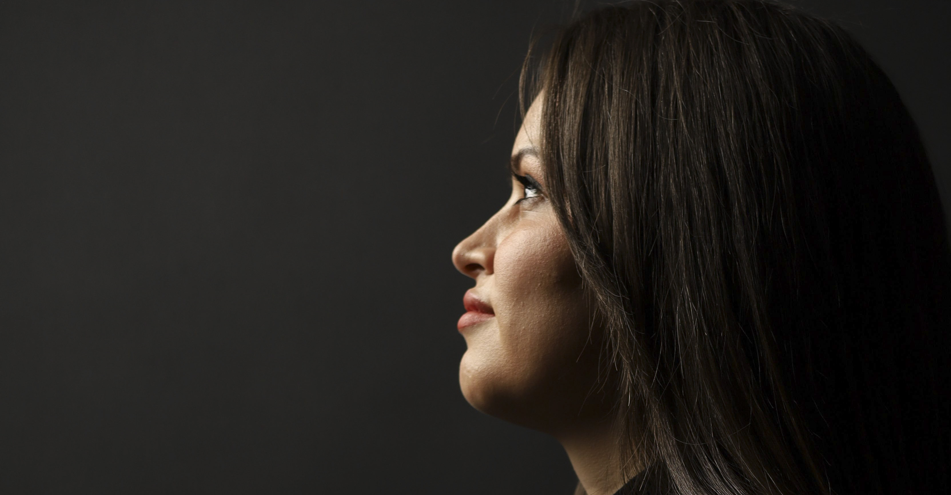 Side-profile portrait of a woman against a dark background